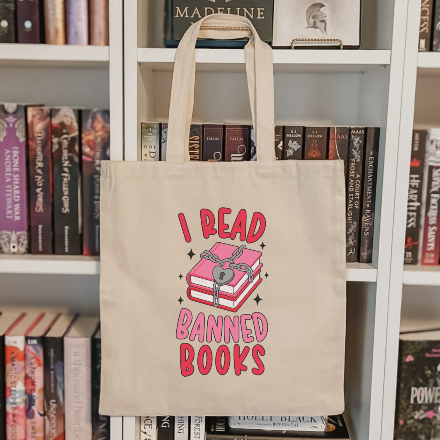 Bookish tote bag with 'I Read Banned Books' design on a bookshelf filled with books.