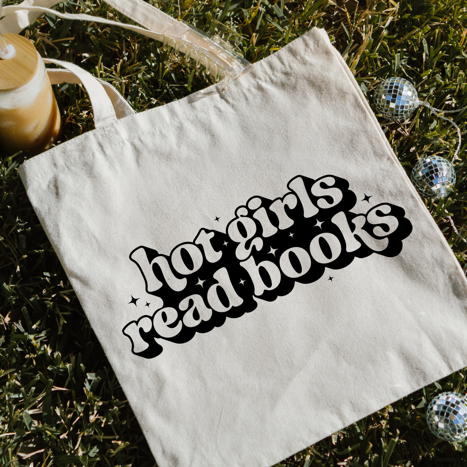 Tote bag with 'hot girls read books' text on grass