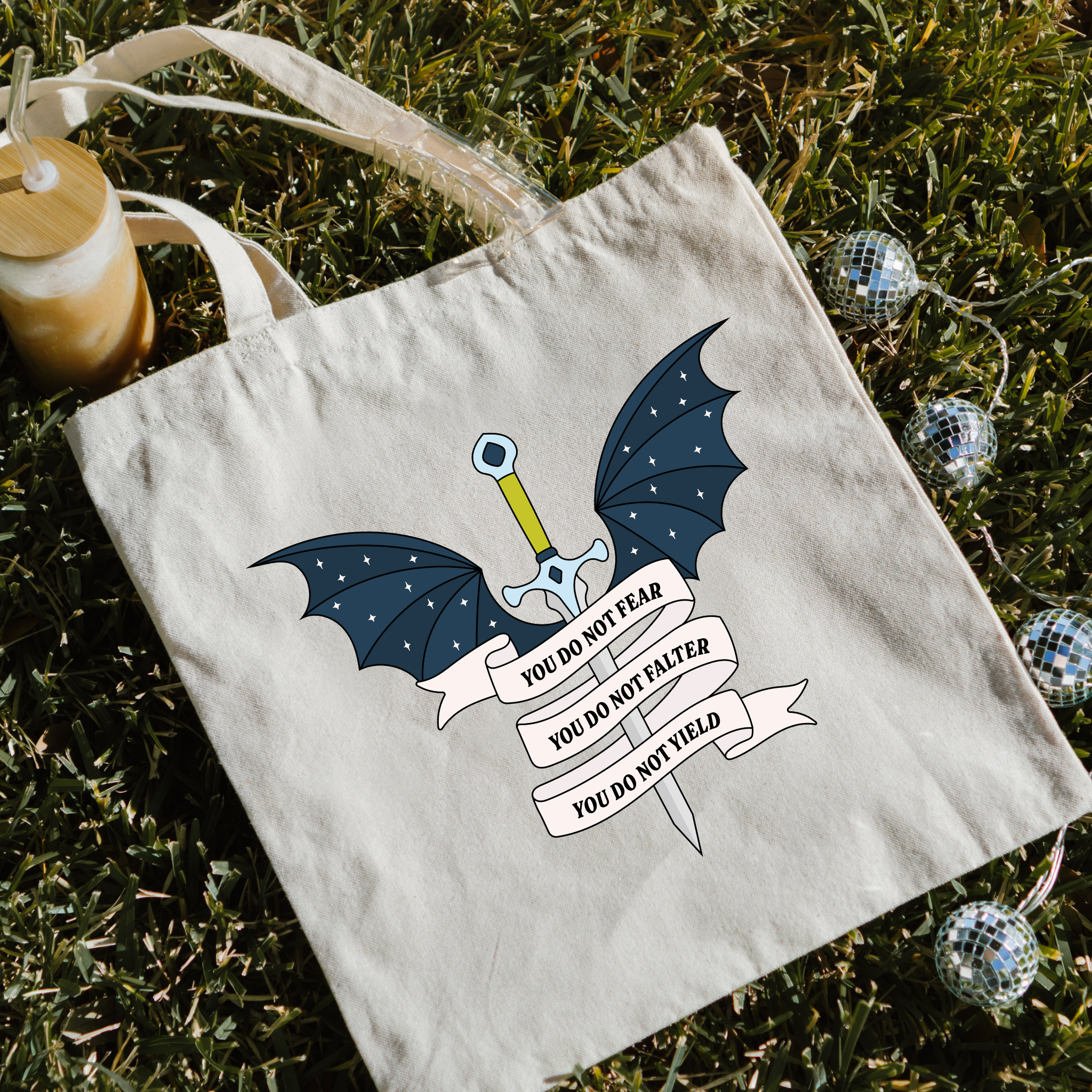 Bookish Tote bag with dragon design and motivational quote on grass