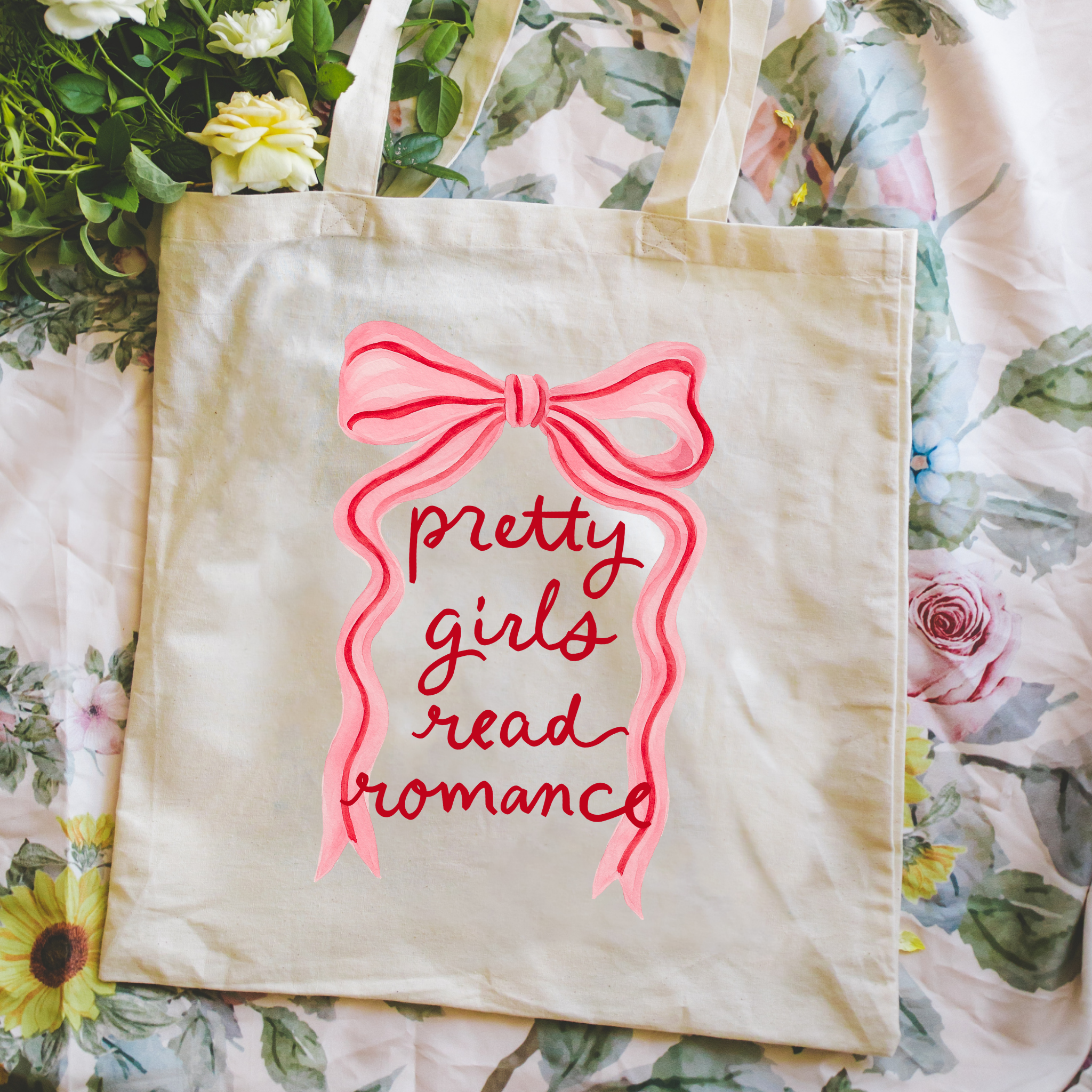 Bookish tote bag with 'pretty girls read romance' text and pink bow on floral background