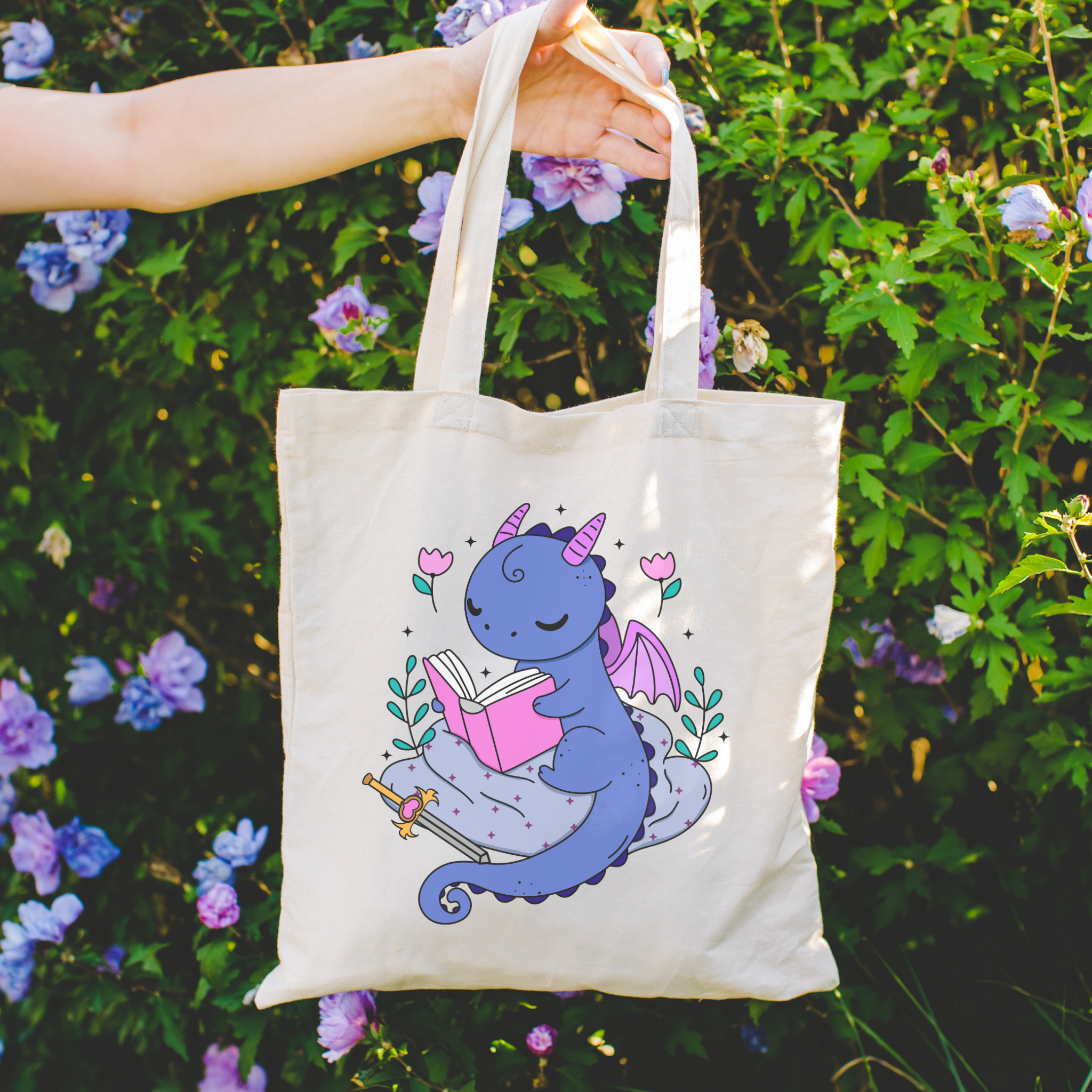 bookish Tote bag with a dragon design holding flowers against a floral background