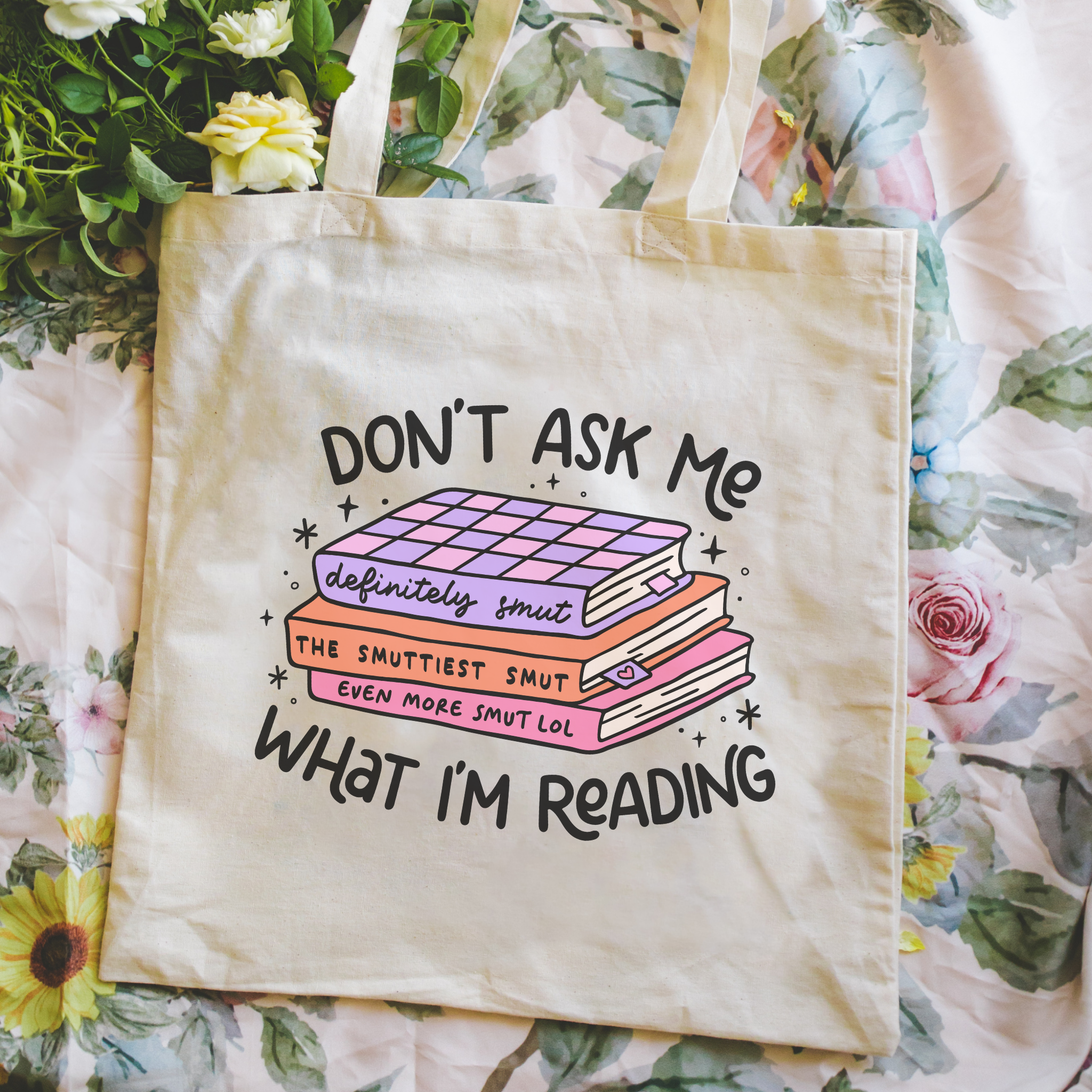 Tote bag with book-themed text on a floral background