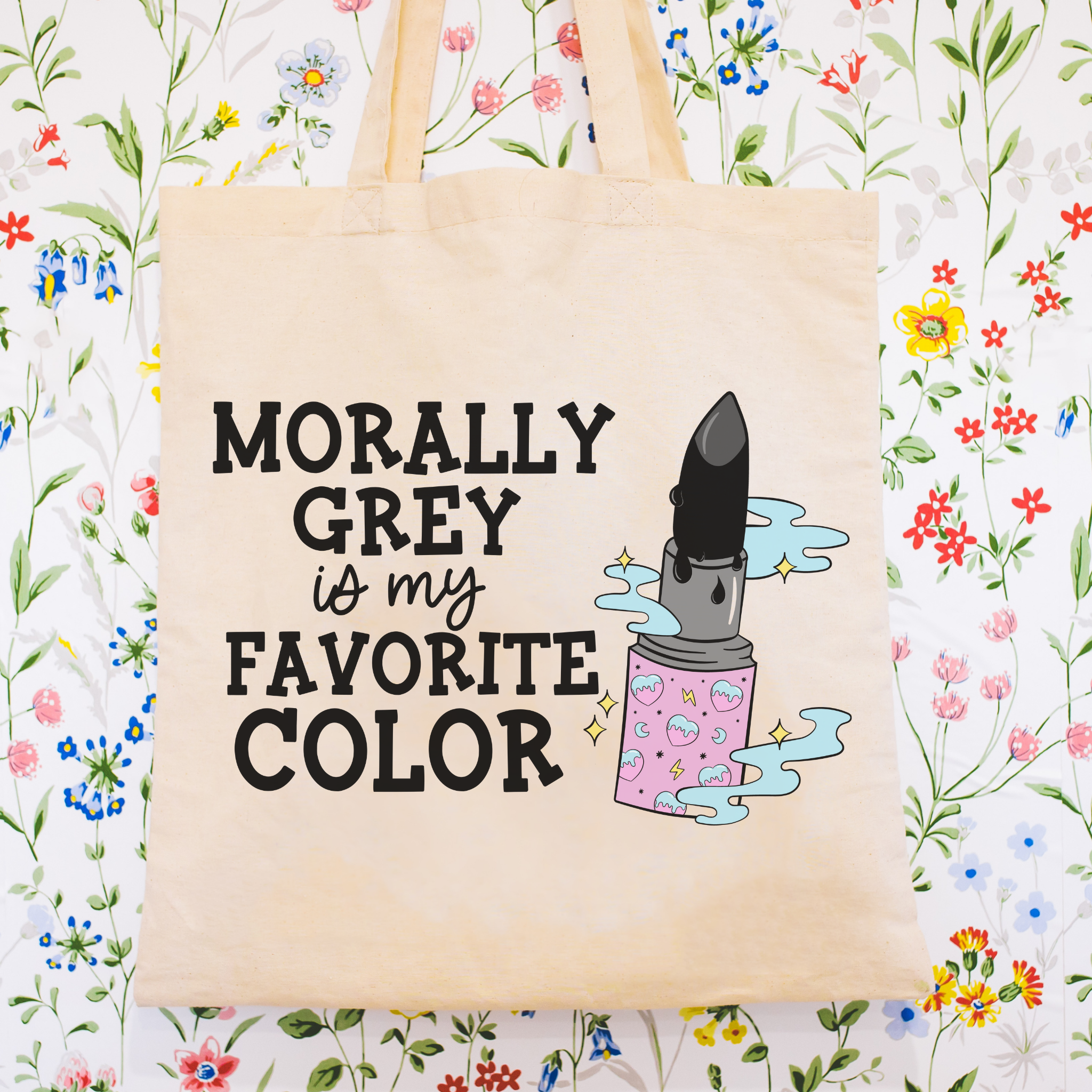 bookish Tote bag with a lipstick graphic and text 'Morally Grey is my Favorite Color' on a floral background
