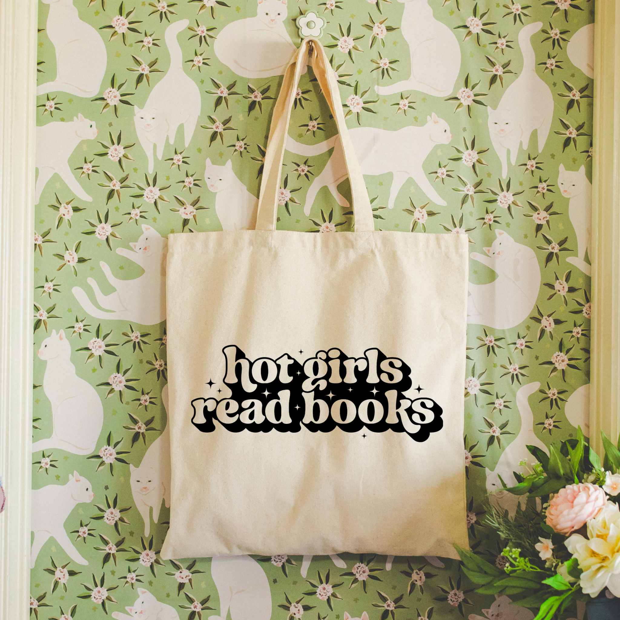 Bookish tote bag with 'hot girls read books' text on a floral wallpaper background