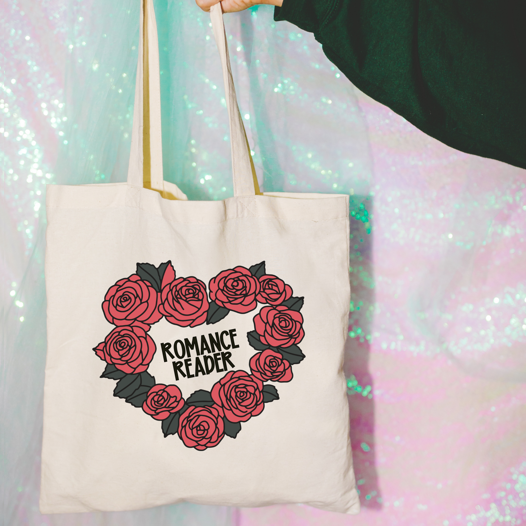Tote bag with rose design and 'Romance Reader' text against a colorful, glittery background