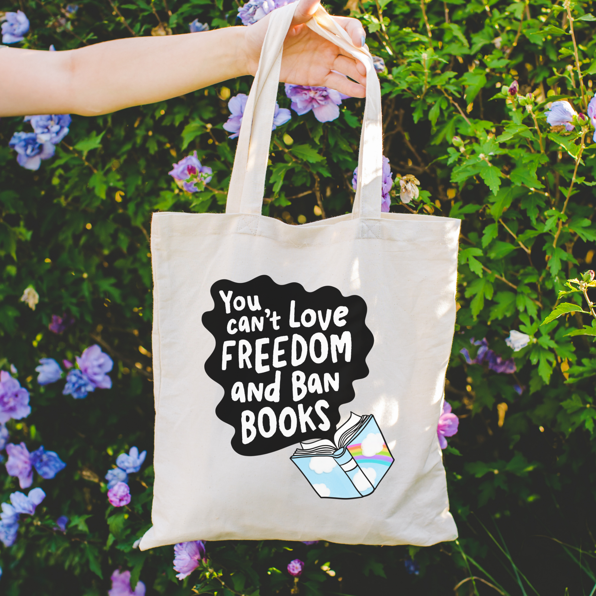Bookish Tote bag with a quote about freedom and banned books held in front of flowers