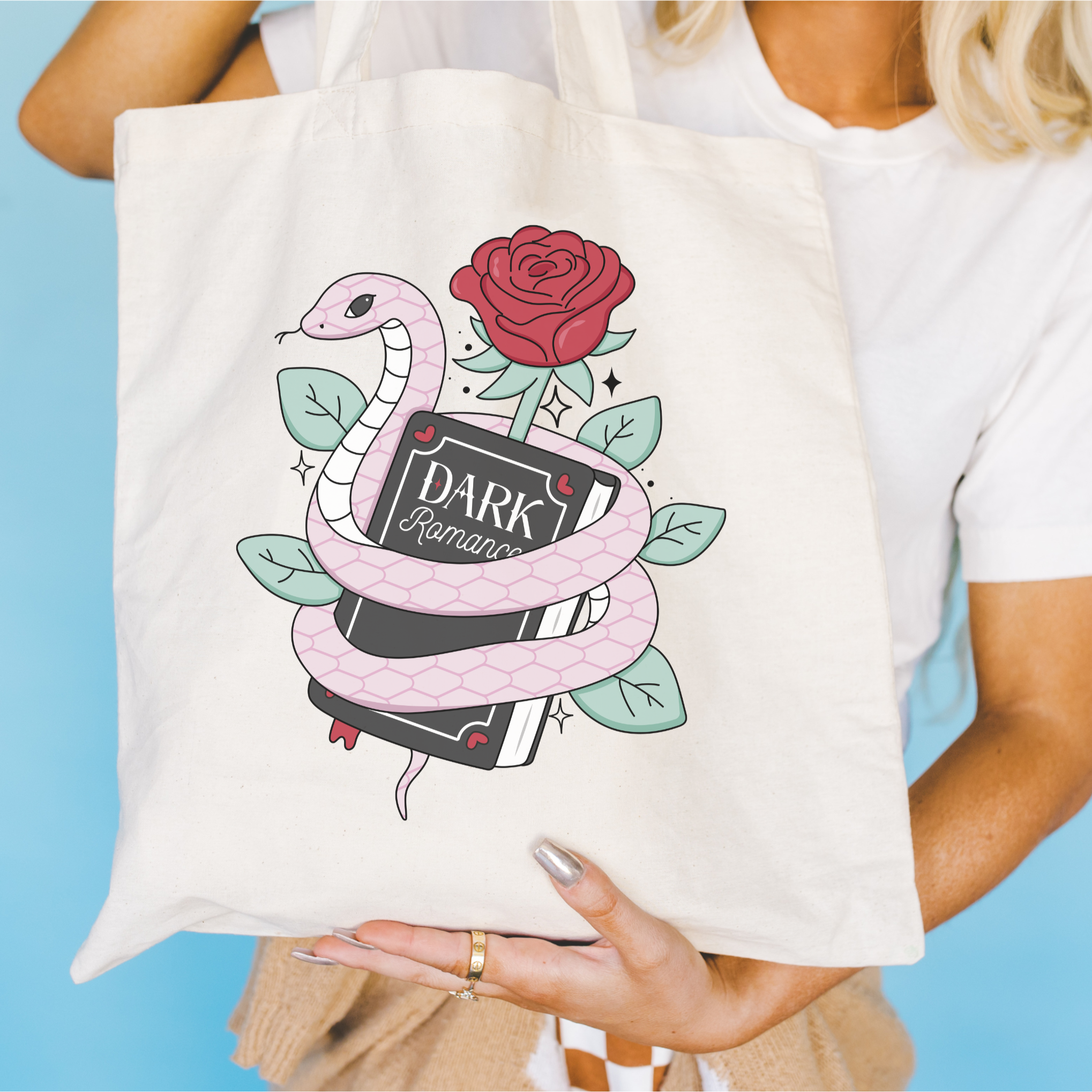 Dark Romance Tote bag with snake and rose design held by a person against a blue background