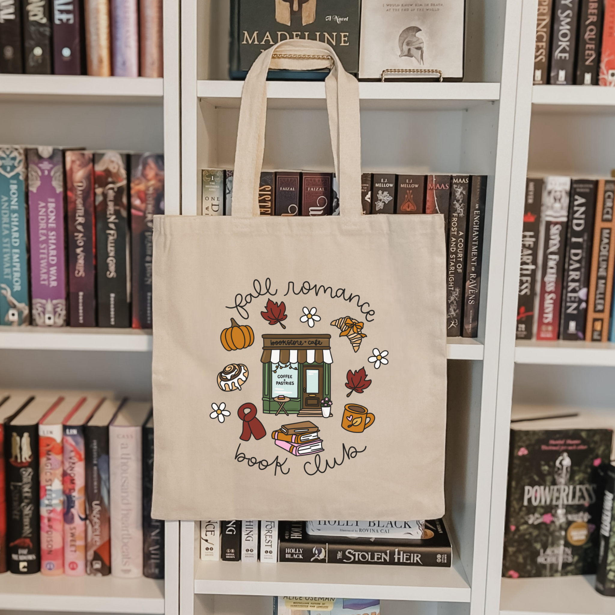 Bookish Tote bag with 'Fall Romance Book Club' design held in front of a floral background