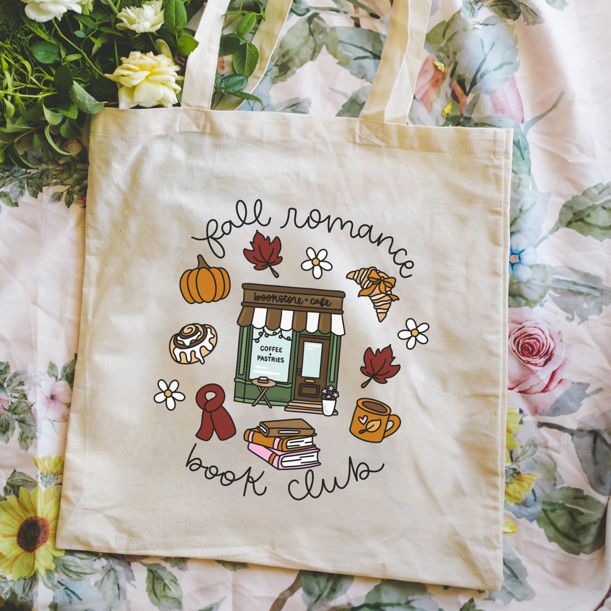 Bookish Tote bag with 'Fall Romance Book Club' design held in front of a floral background
