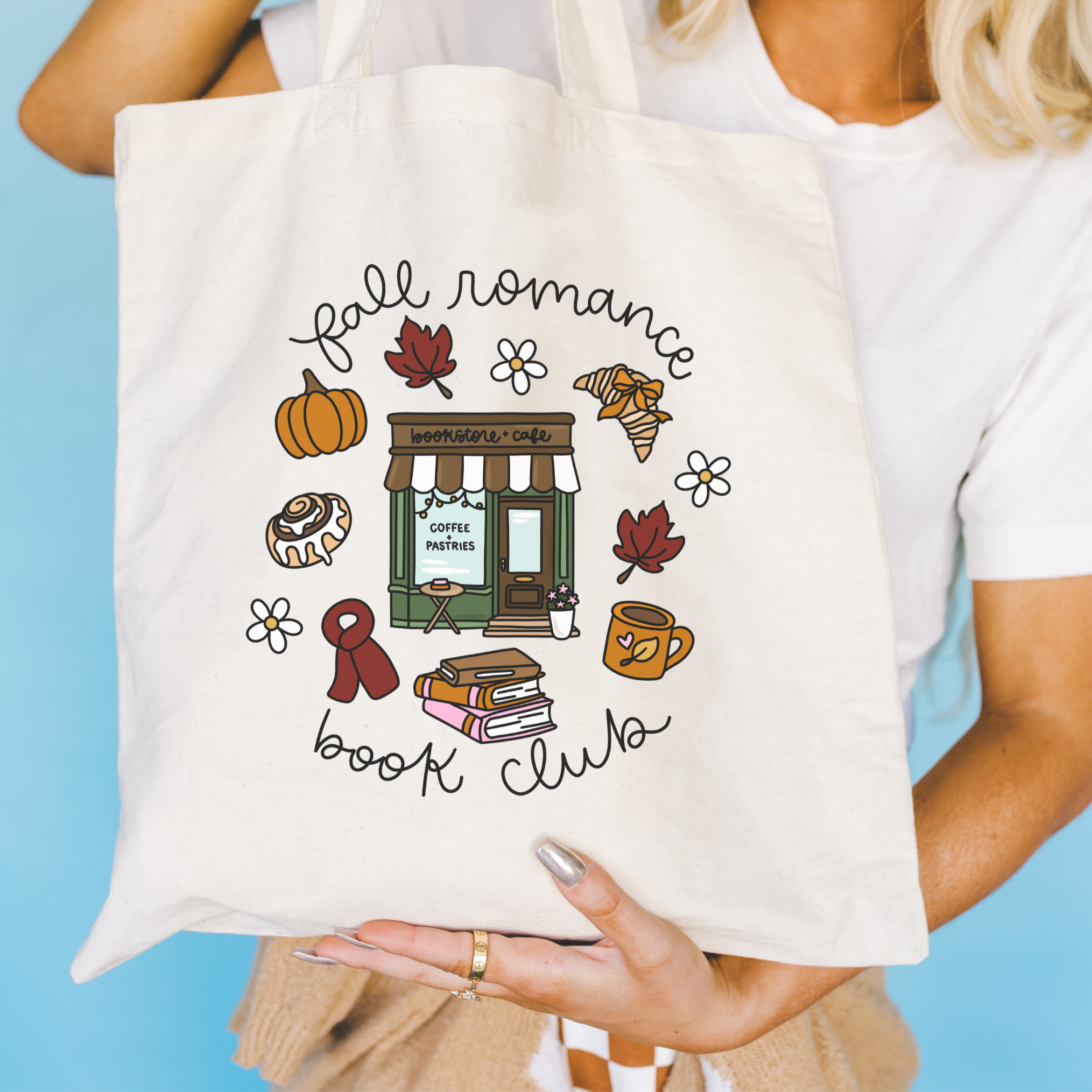 Bookish Tote bag with 'fall romance book club' design held by a person against a blue background