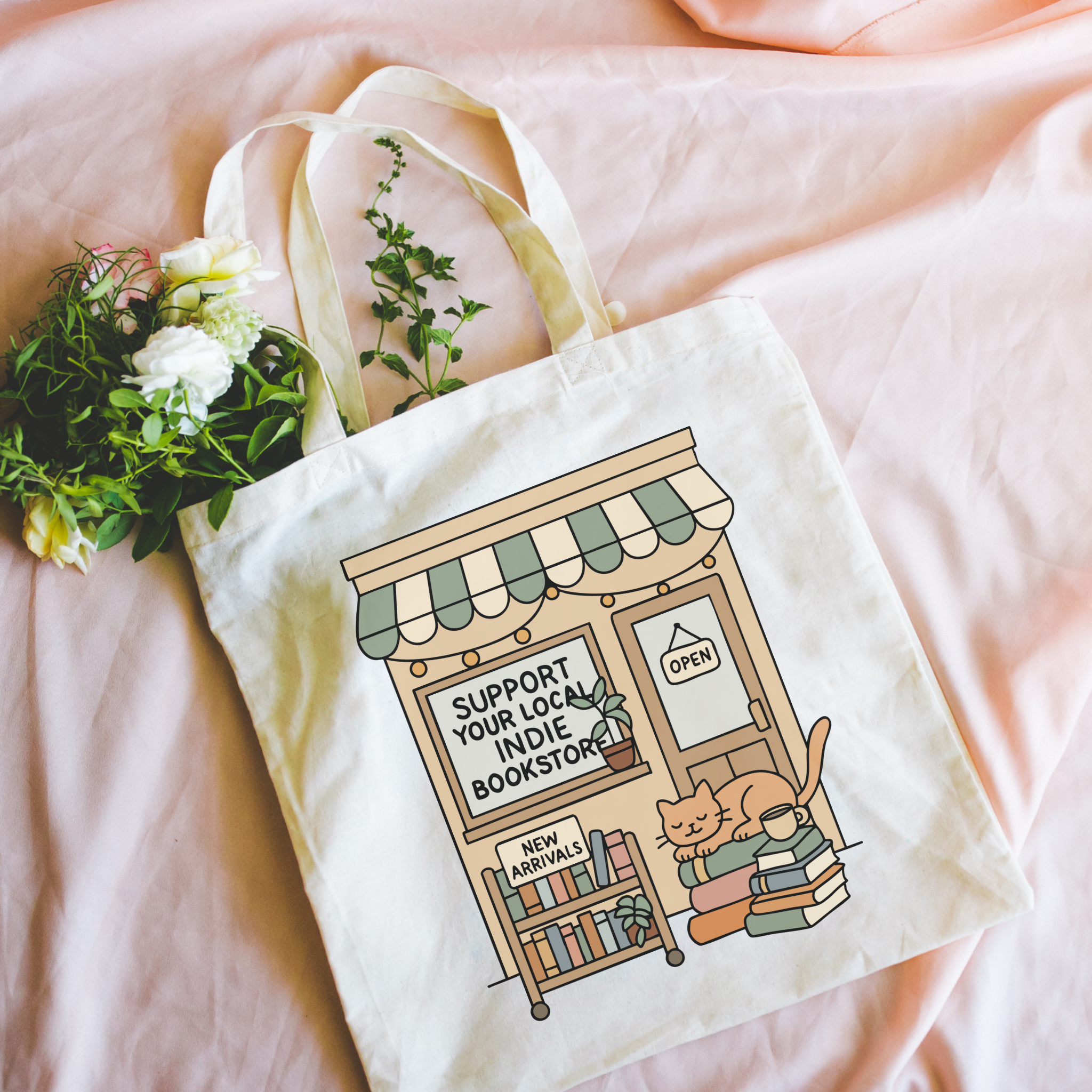 Tote bag with a design of a bookstore and text 'Support Your Local Indie Bookstore' on a pink surface.