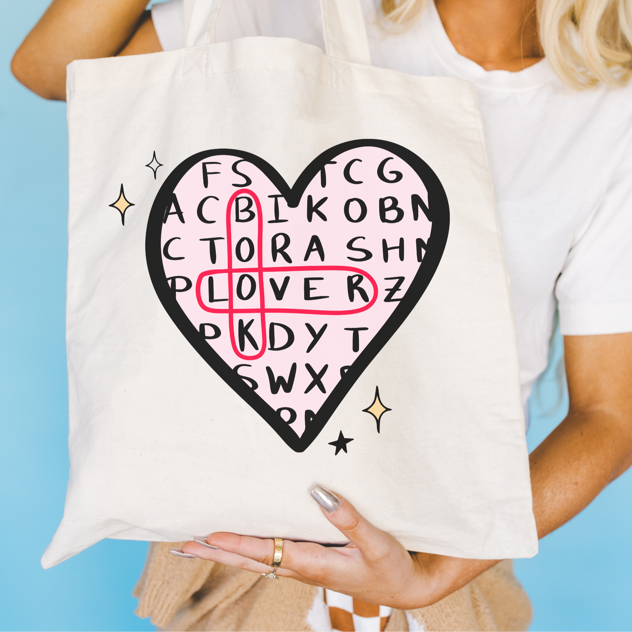 Person holding a tote bag with a heart-shaped design and text on a blue background