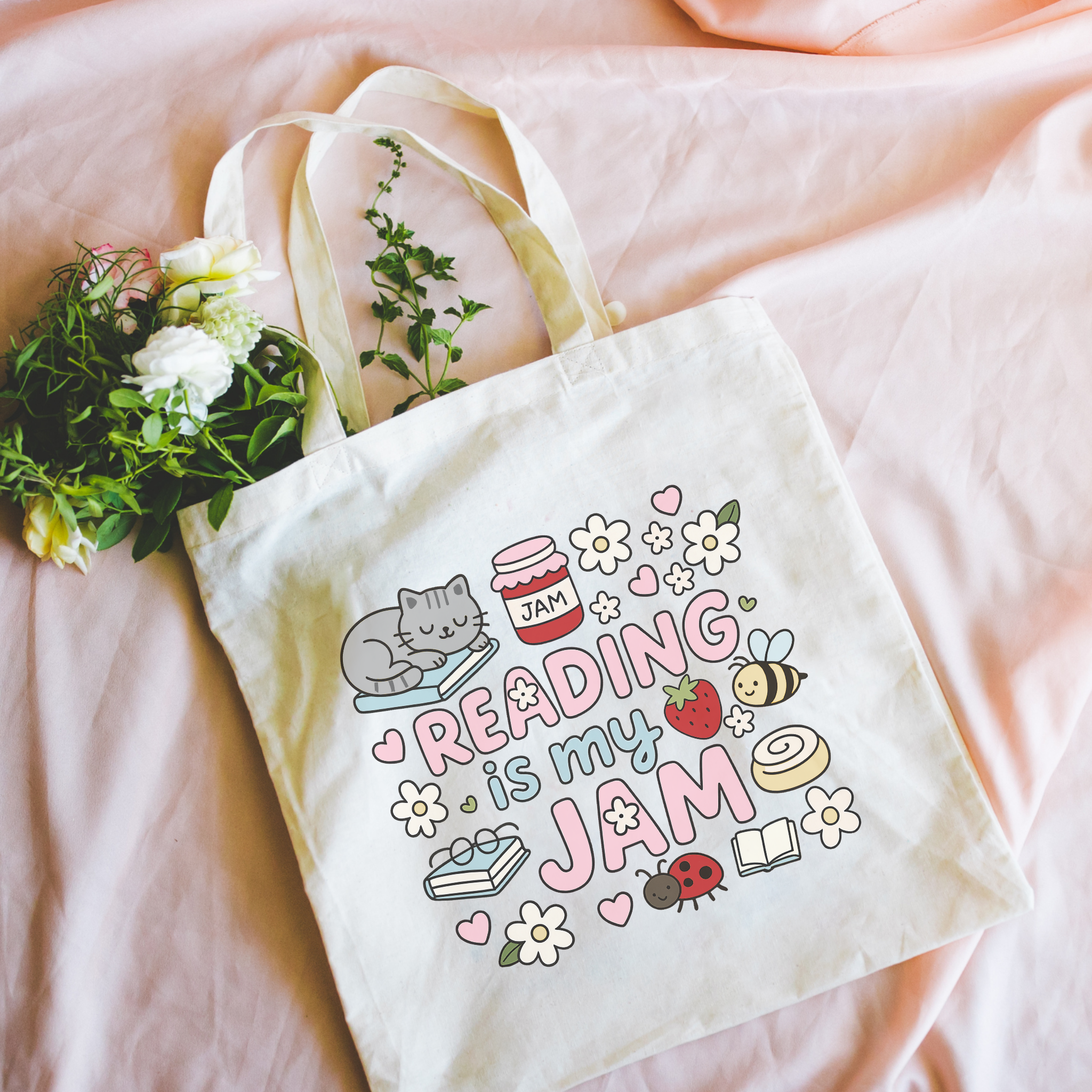 Bookish Tote bag with 'Reading is my Jam' design on a pink surface with flowers