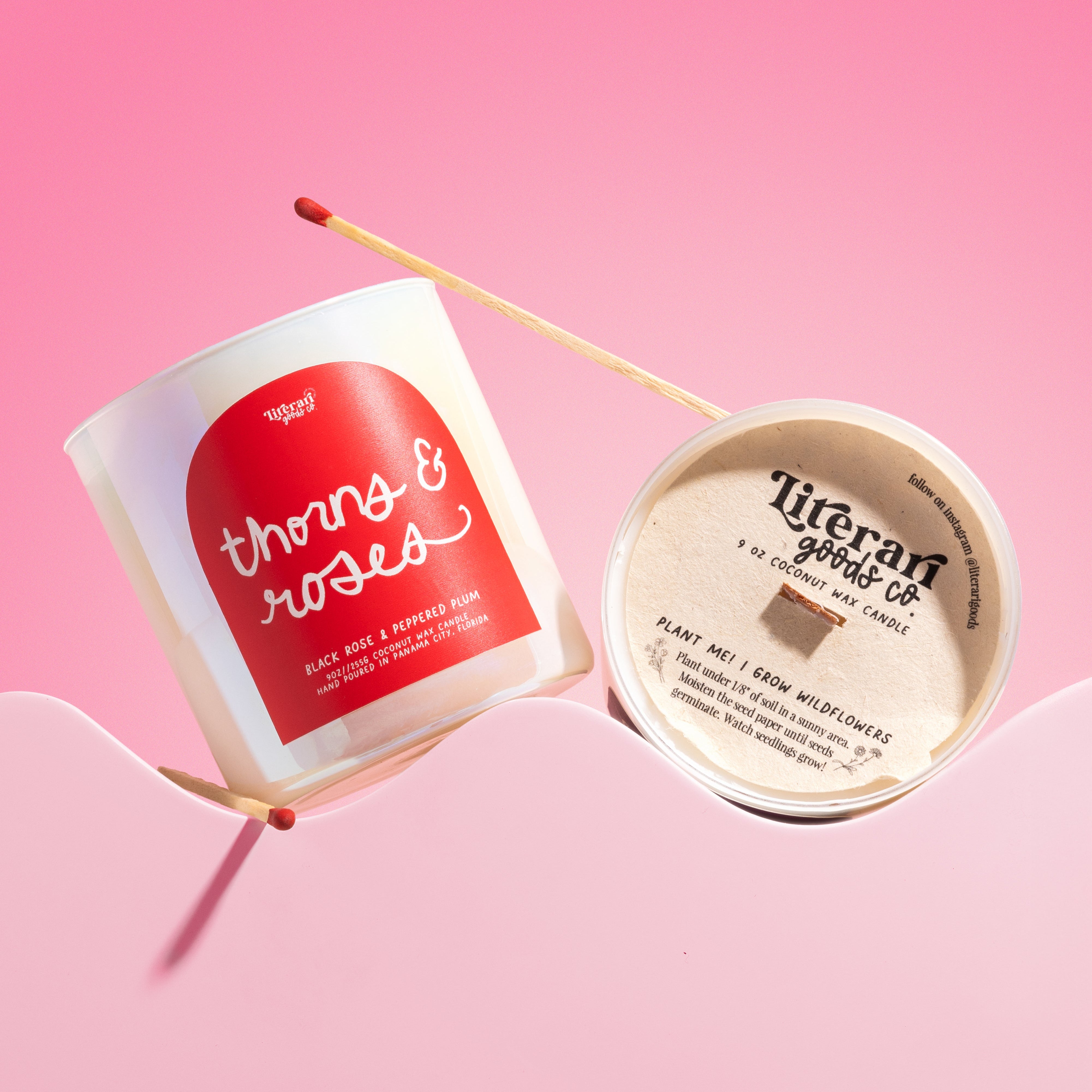 Candle with 'thorns & roses' design and 'Literary Goods Co.' branding on a pink background