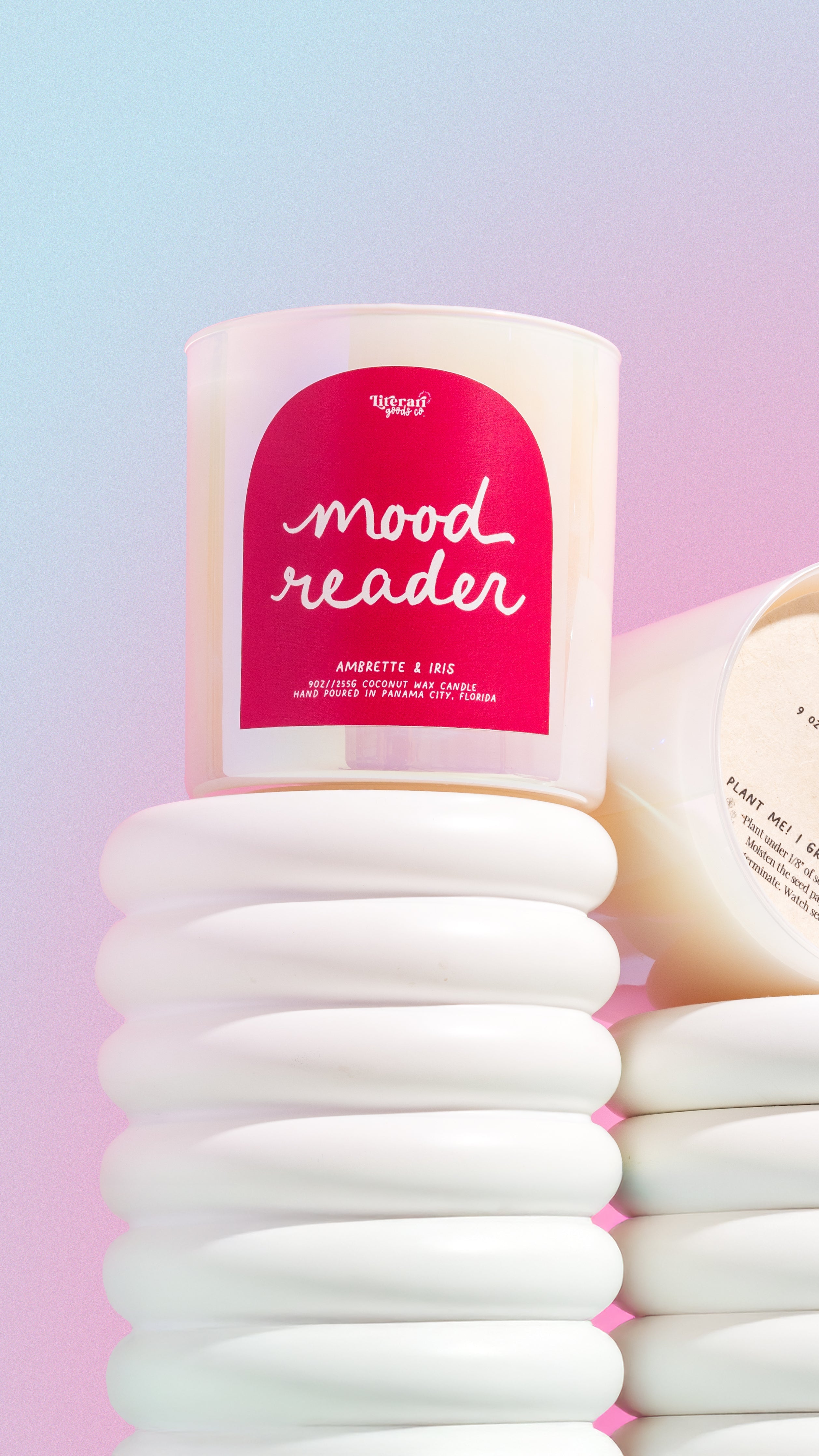 bookish Candle labeled 'mood reader' with a stack of white cotton pads on a gradient background