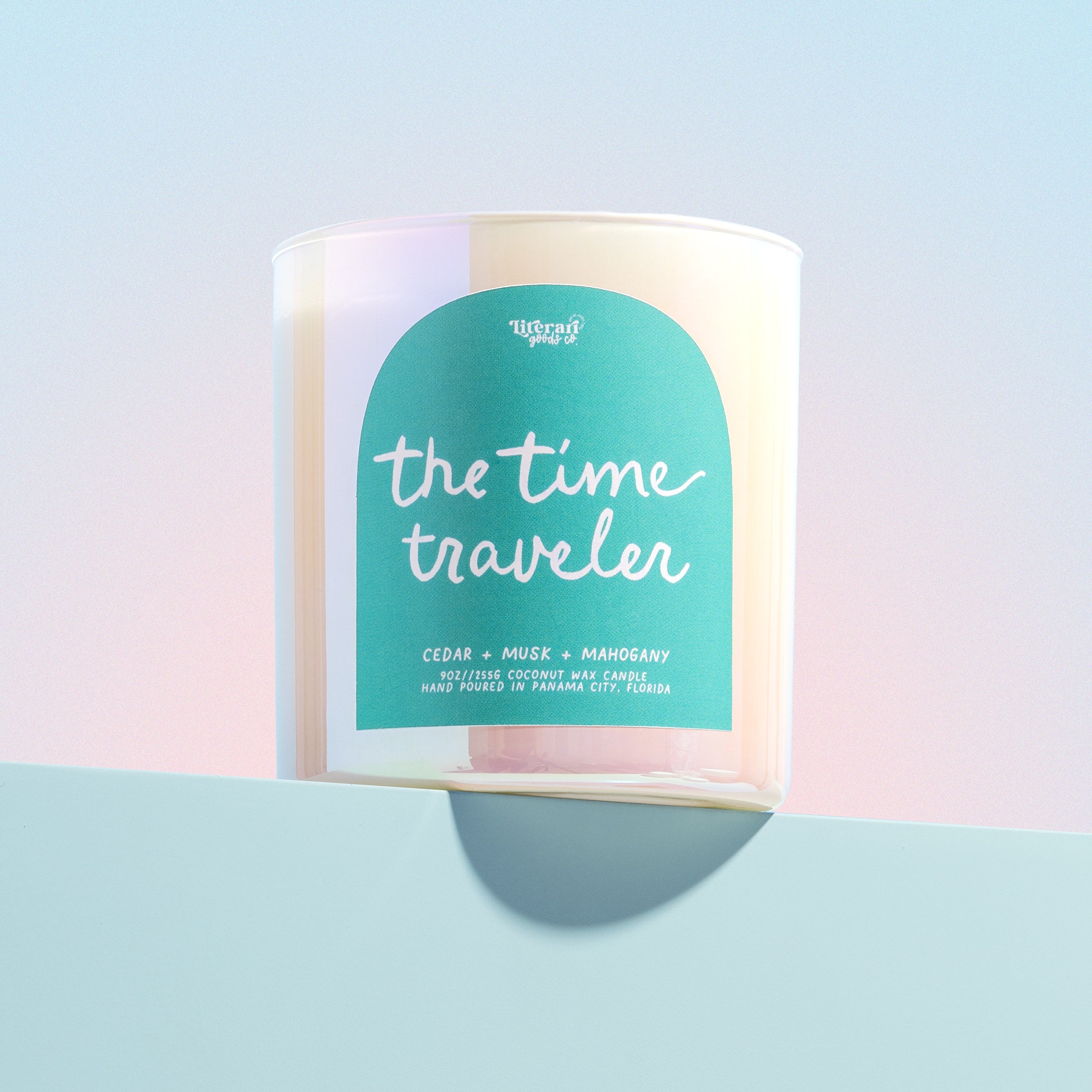 bookish Candle labeled 'the time traveler' with a pastel gradient on a light blue background