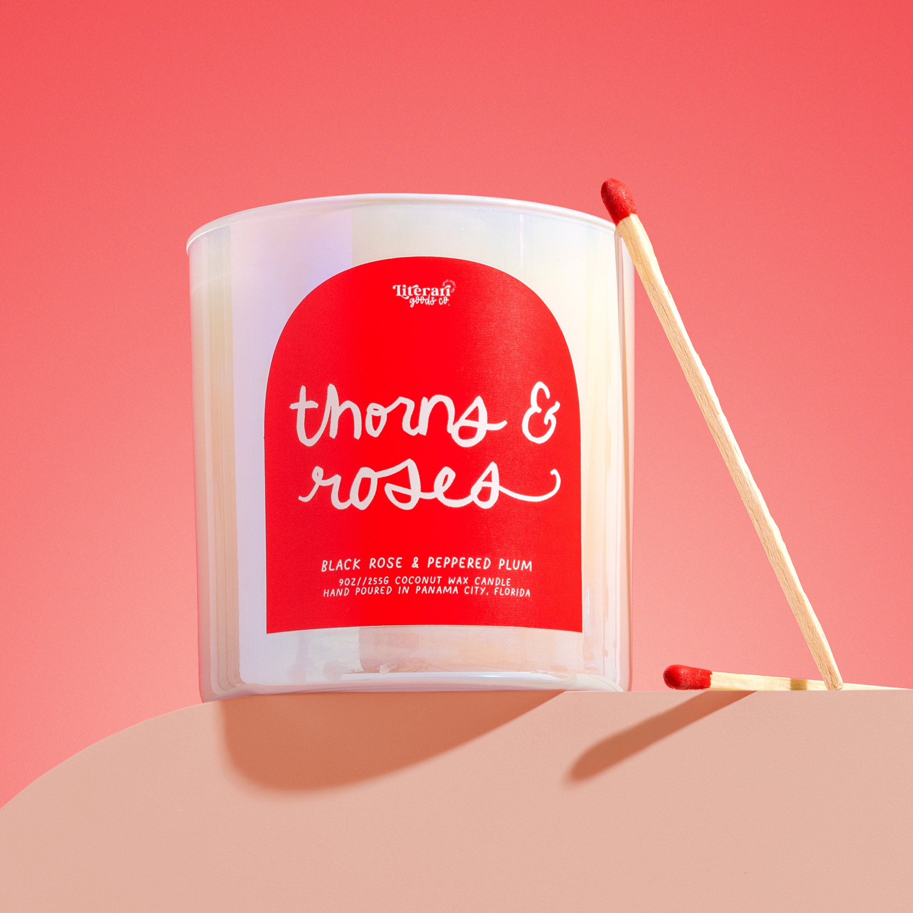 Candle with a red label on a pink background