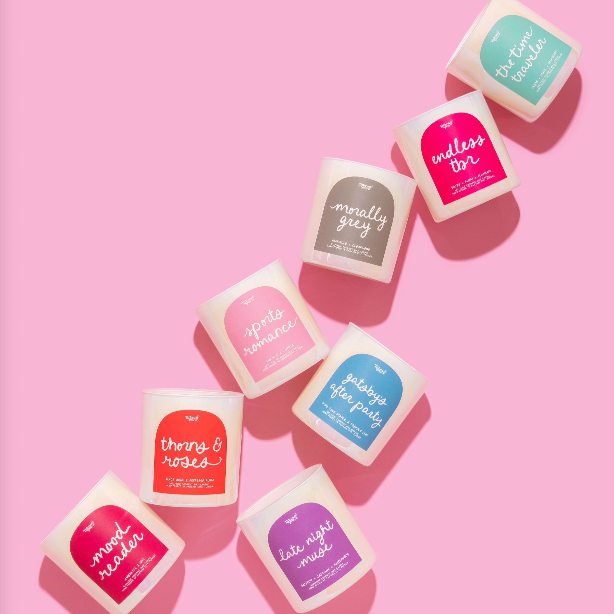 Assorted romance book themed candles on a pink background